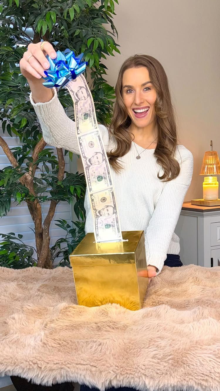 9 Funny Money Gift Ideas to Make Cash Feel Like a Gift 6 Woman pulling a long string of cash from a gold gift box
