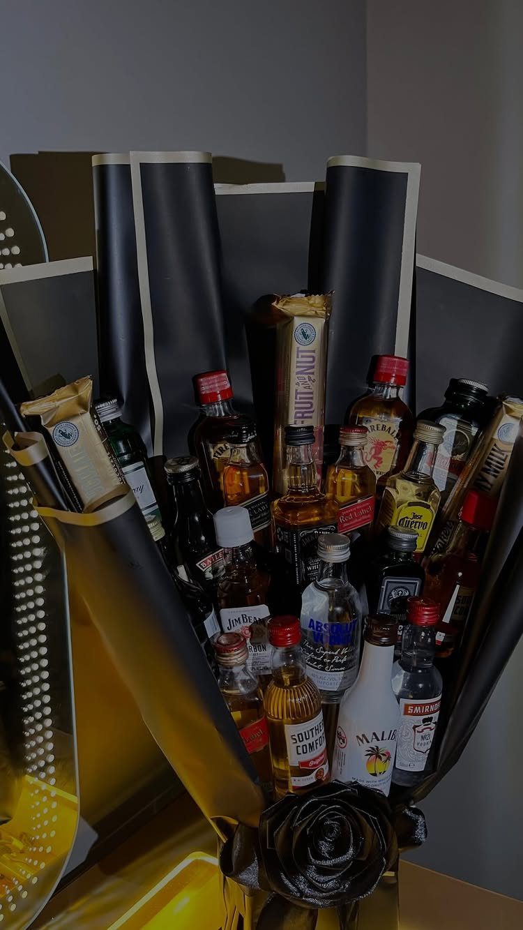 15 Gift Basket Alternative Ideas for Any Occasion 14 Miniature liquor bottles and snacks arranged as a bouquet in black and gold wrapping.
