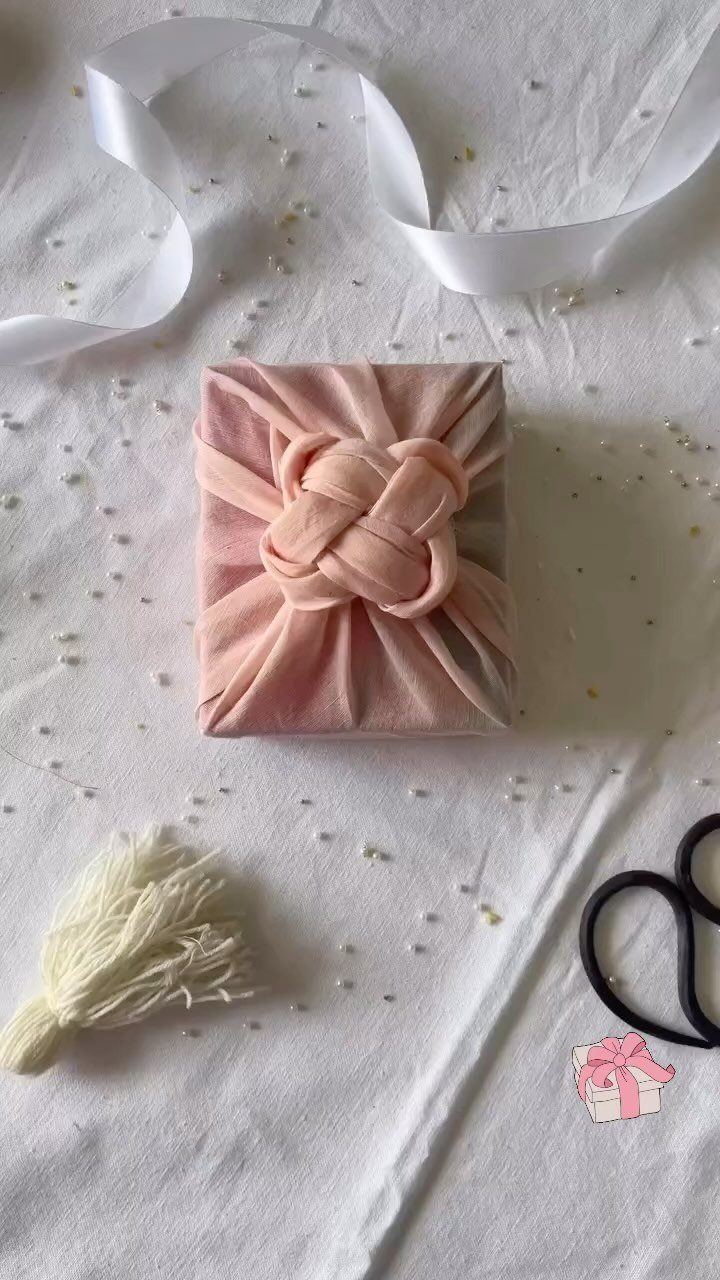15 Gift Basket Alternative Ideas for Any Occasion 1 Gift wrapped in pink fabric with a knot on white textured background