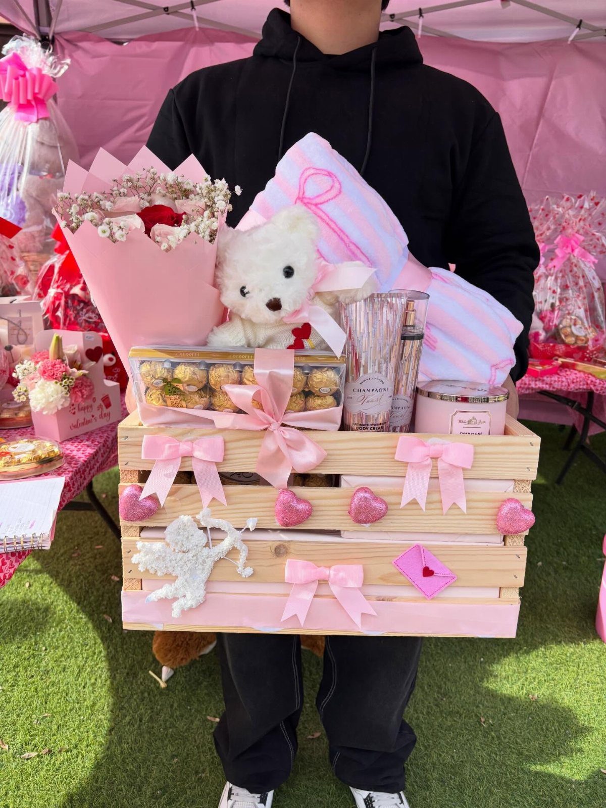 15 Gift Basket Alternative Ideas for Any Occasion 13 Pink wooden crate gift set with teddy bear, blanket, and flowers held by person