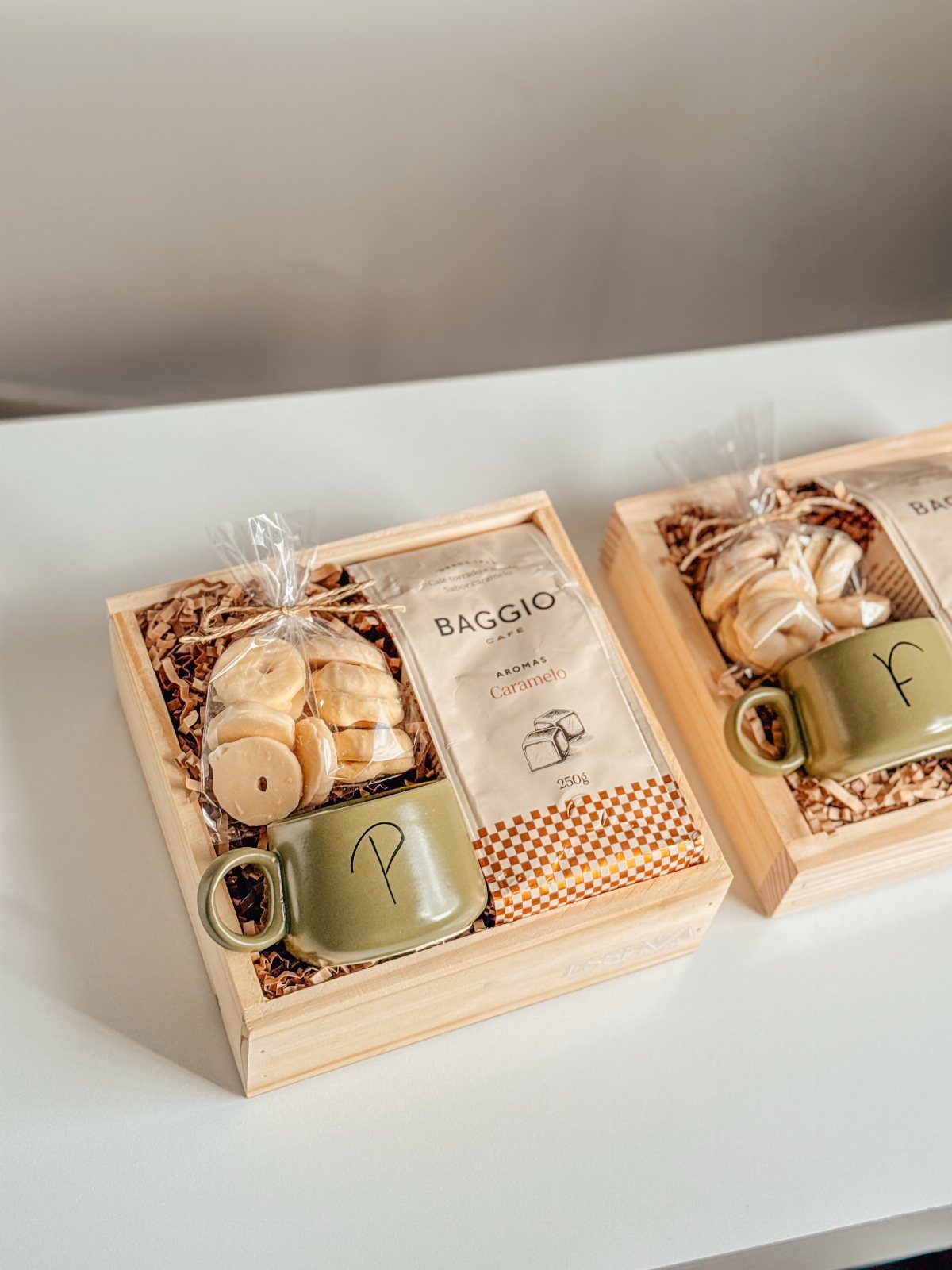 Gift Basket Design: 18 Ideas for Every Occasion 4 Two wooden gift trays with green mugs, cookies, and Baggio coffee packages.
