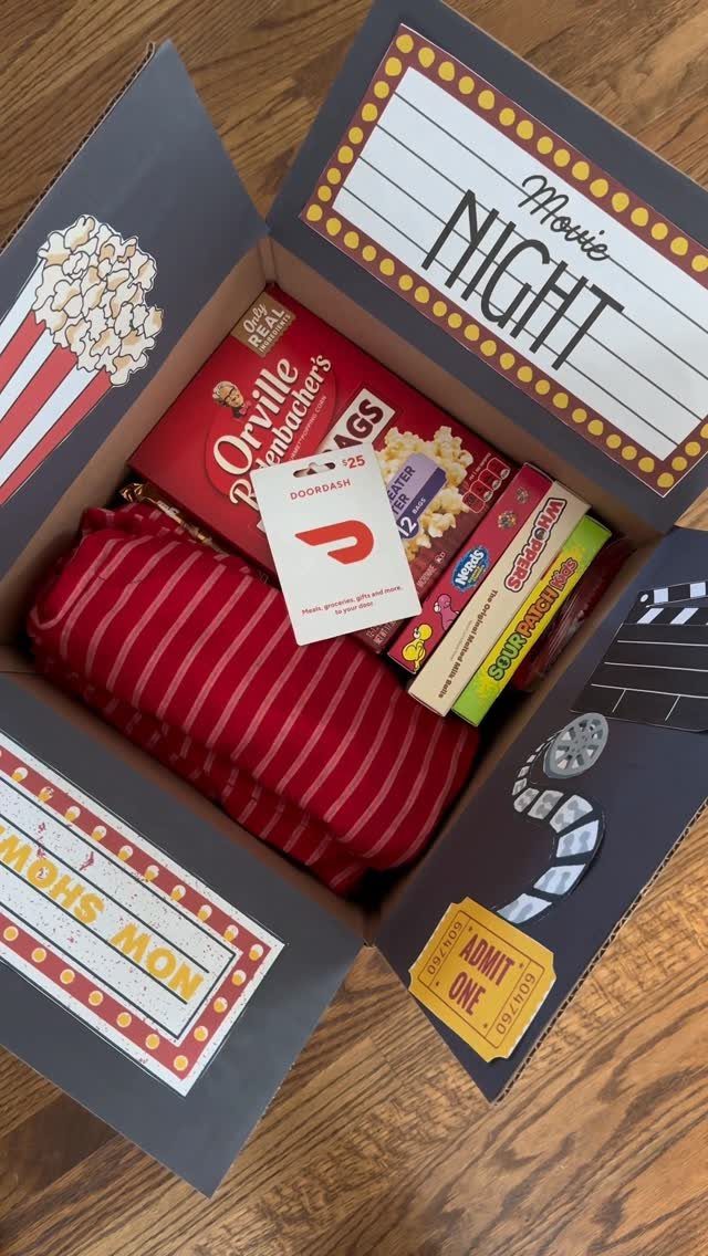 Movie night gift box with popcorn, candy, and a red striped blanket.