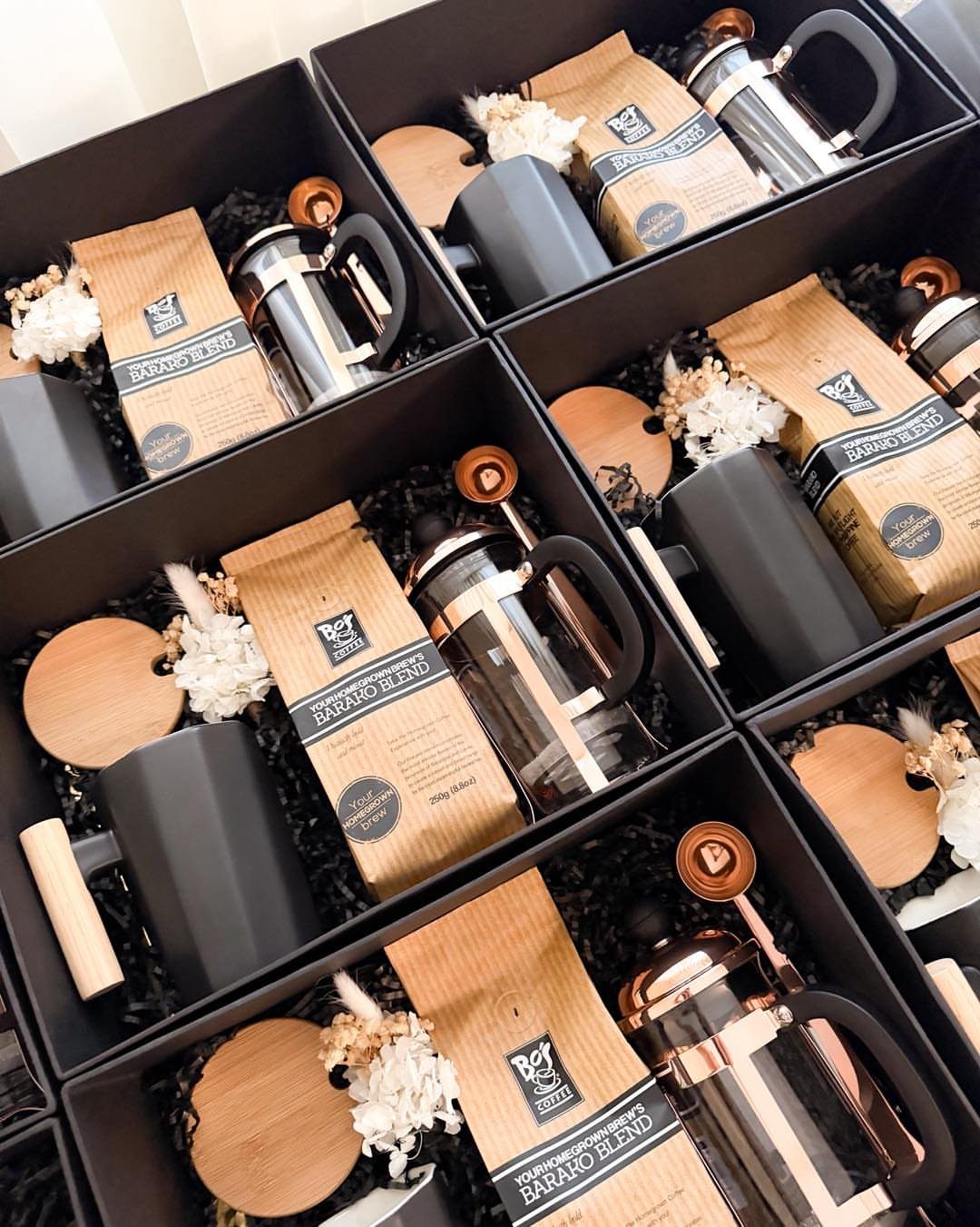 18 Gift Basket Prize Ideas for Raffles and Auctions 4 Coffee gift baskets containing French presses, coffee bags, and black mugs in black boxes.