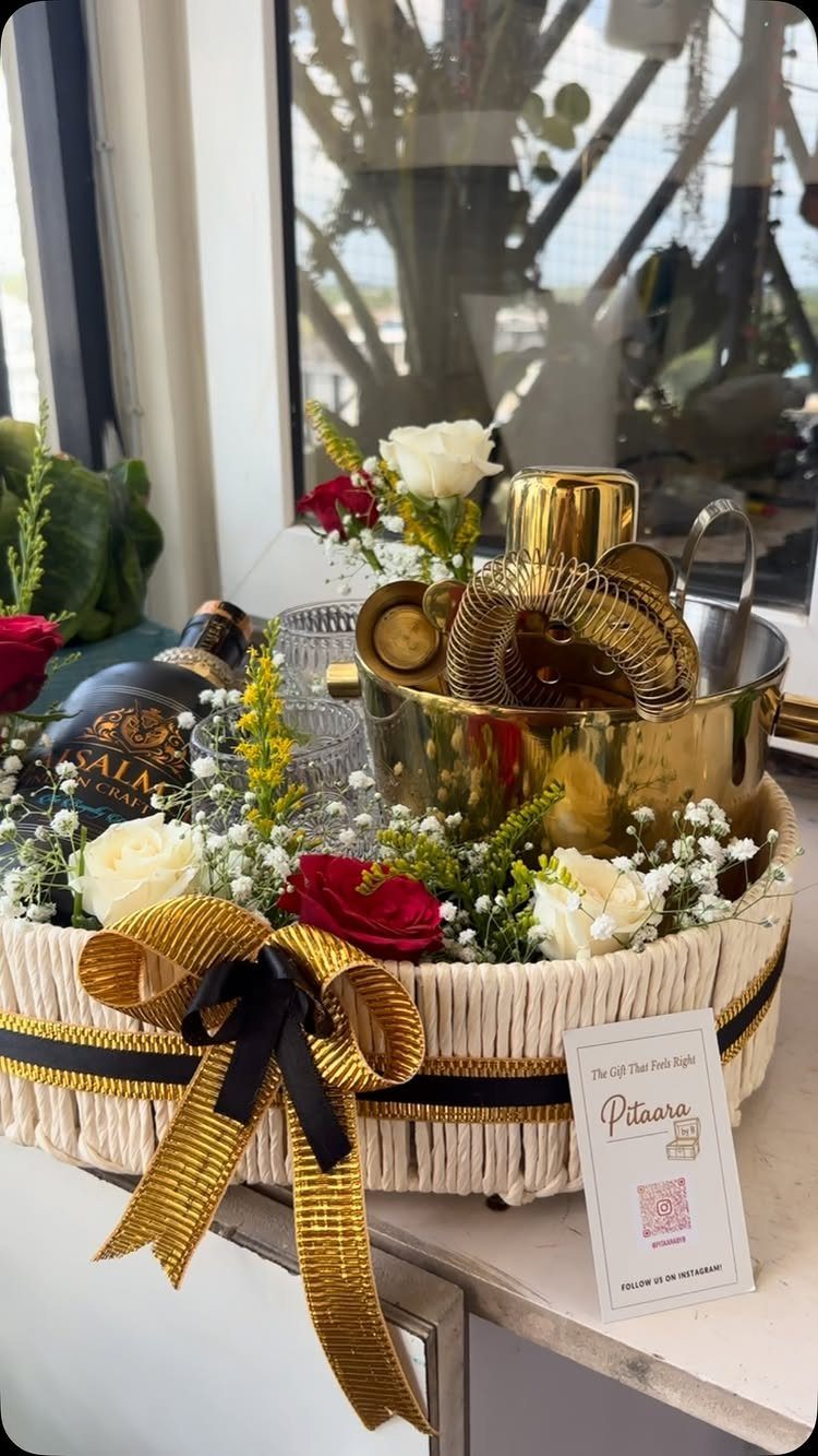 18 Gift Basket Prize Ideas for Raffles and Auctions 10 Gift basket with gold cocktail tools, a bottle of liqueur, and fresh roses.