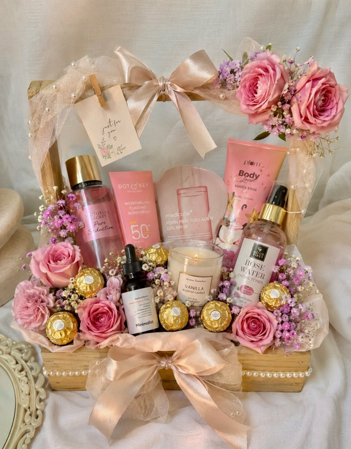 18 Gift Basket Prize Ideas for Raffles and Auctions 3 Wooden gift basket with pink skincare products, roses, and chocolates tied with beige ribbons.