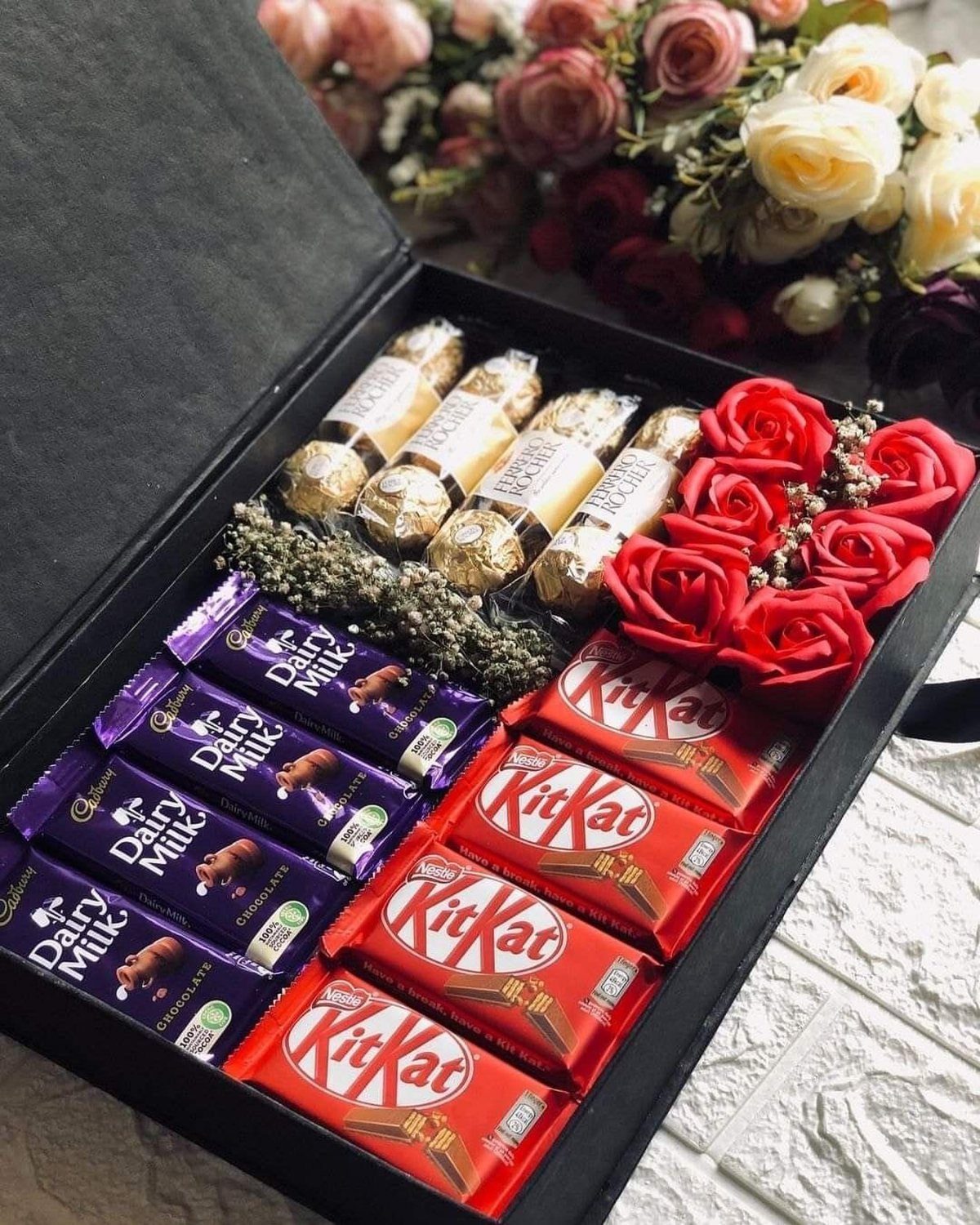 Gift Basket for Wedding: 5 Ideas for Couples and Guests 4 Black gift box filled with assorted chocolates and red roses for a celebration.