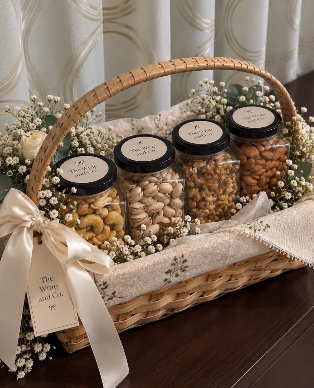 Gift Basket for Wedding: 5 Ideas for Couples and Guests 1 Woven gift basket with four jars of gourmet nuts and white flowers.