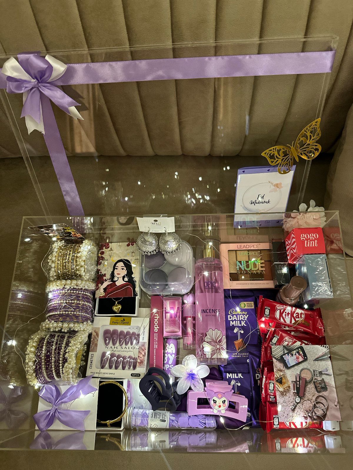8 Gift Box Images: Red, Black, Pink, Blue and Clear 6 Clear acrylic gift box filled with pink beauty products and purple ribbons.