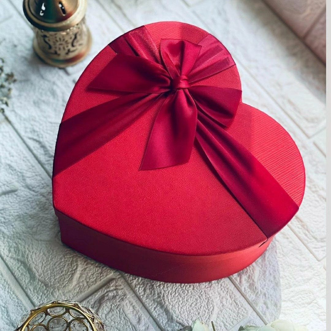 8 Gift Box Images: Red, Black, Pink, Blue and Clear 1 Heart-shaped red gift box with a red satin ribbon bow on white bricks