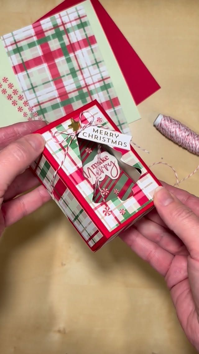 Plaid Christmas gift box with a white string bow and Merry Christmas tag.