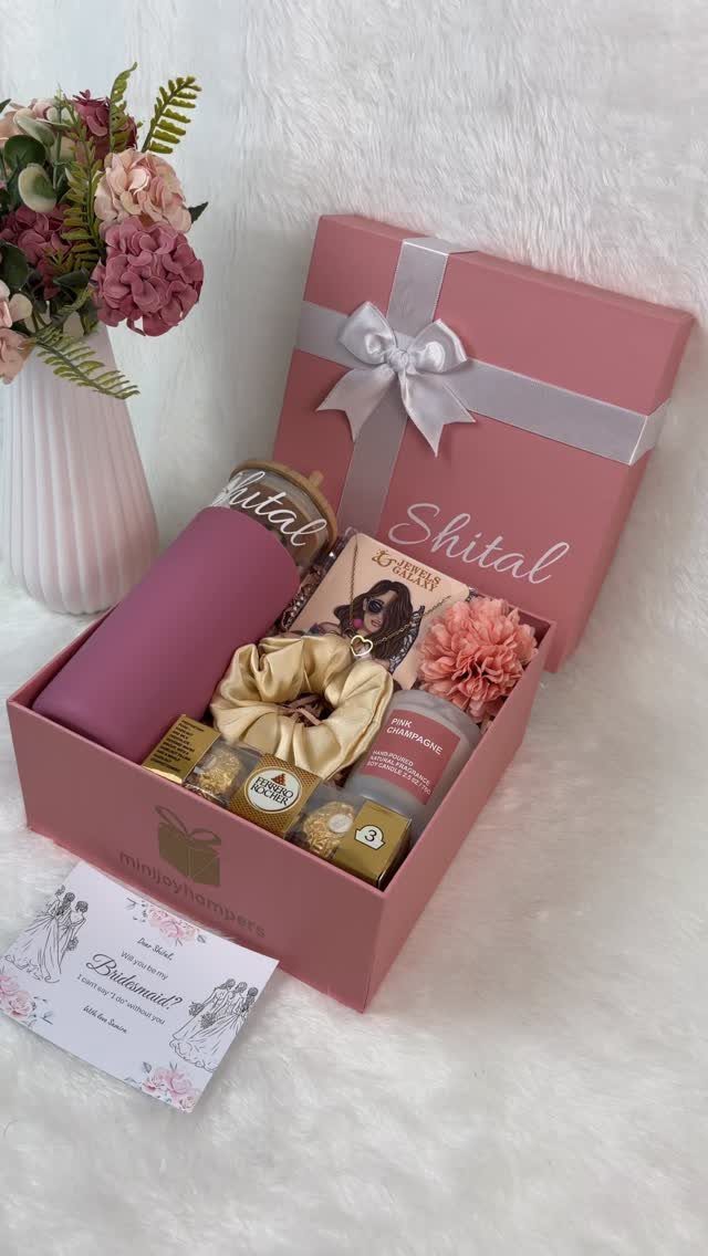 Pink gift box with a tumbler and scrunchie next to a handwritten card