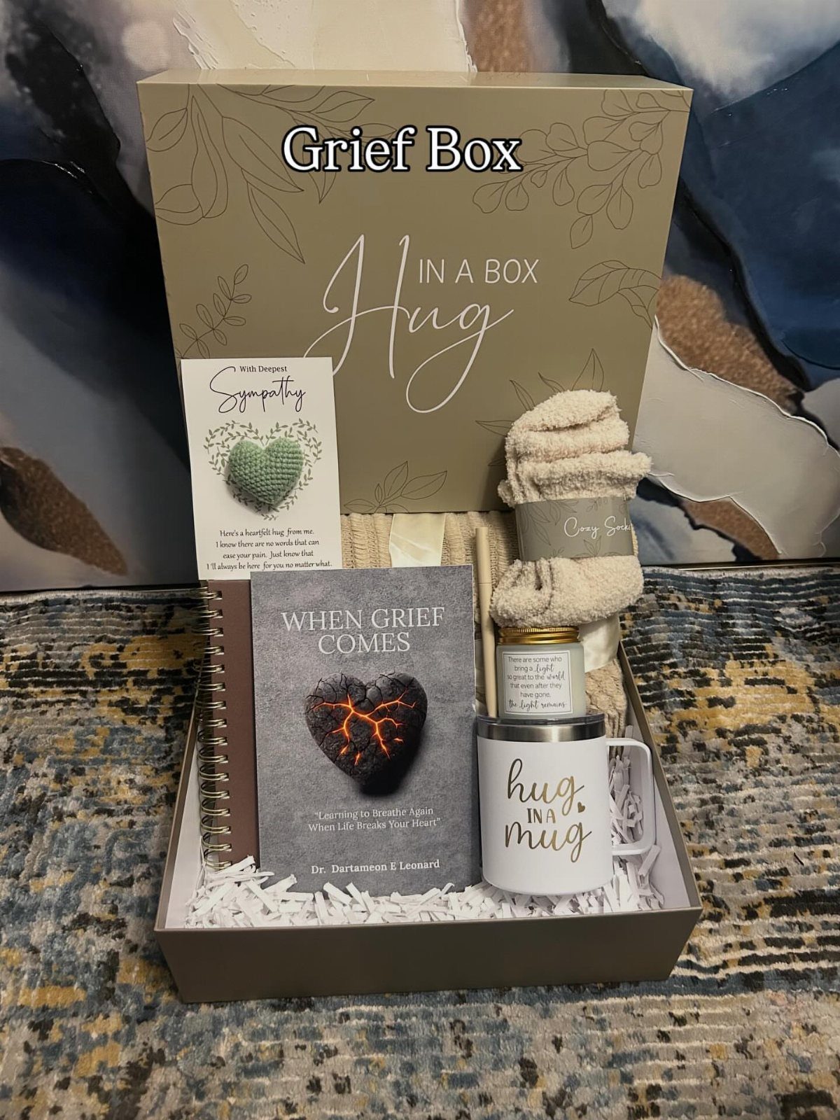 Grief gift box with a sympathy book, cozy socks, and a hug mug.