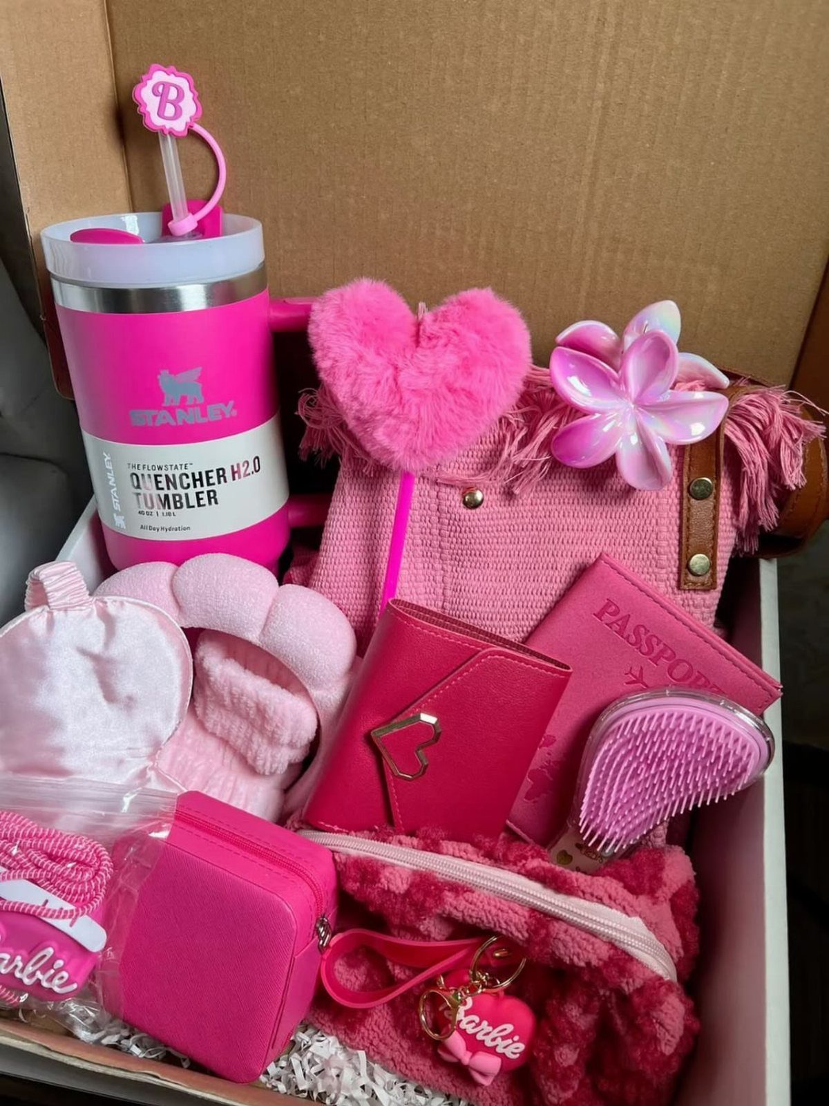 Pink gift hamper containing a Stanley tumbler, handbag, wallet, and beauty accessories.