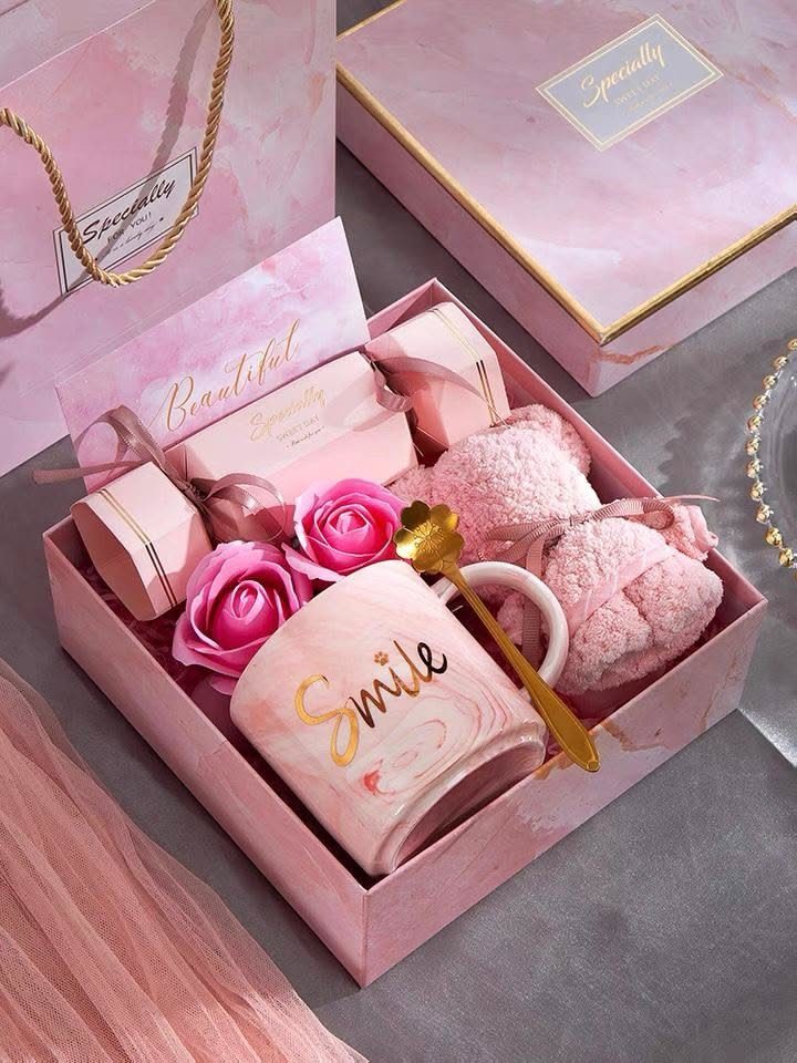 Pink marble gift box with a Smile mug, roses, and beauty products.
