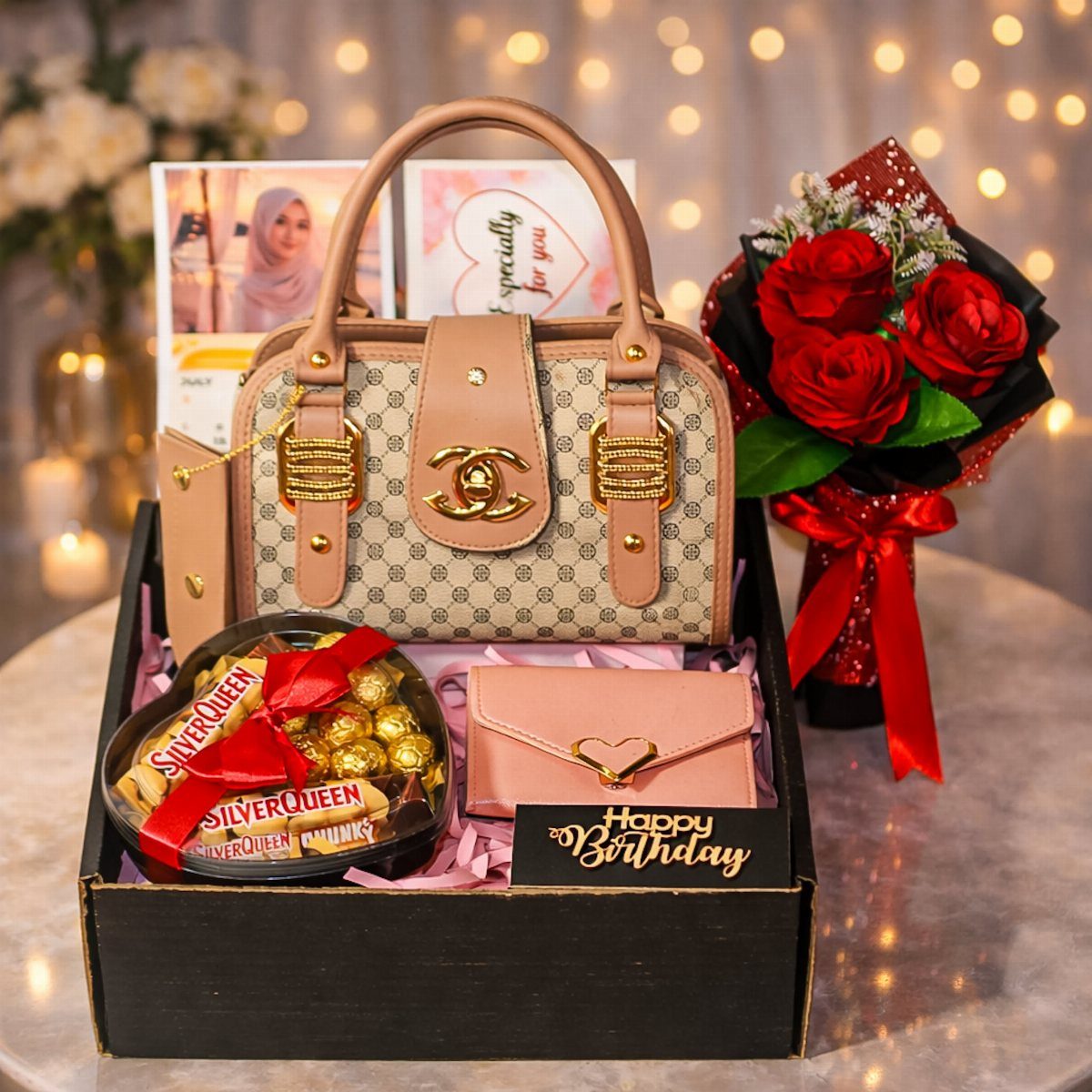 Gift box with beige handbag, pink wallet, chocolates, and red rose bouquet.