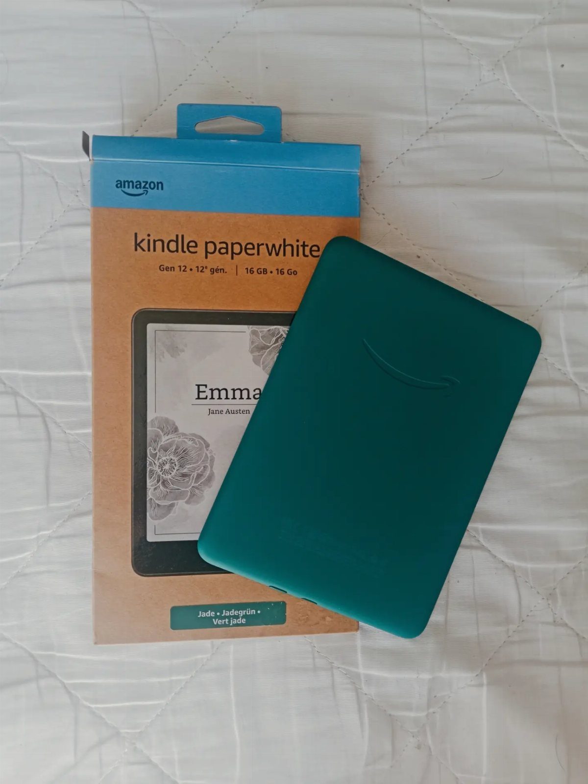 7 Gift Ideas on Amazon: Cozy, Techy and Easy to Wrap 2 Teal Kindle Paperwhite e-reader with case resting on its original Amazon packaging.