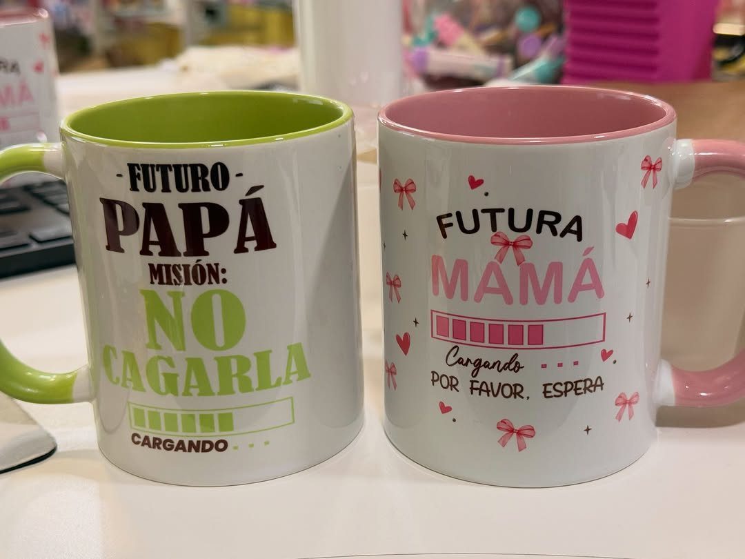 Two ceramic mugs for future parents with Spanish text and loading bars.