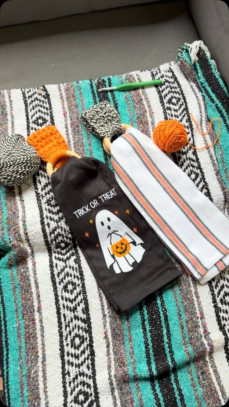 11 Gifts for Halloween Lovers: Candles, Socks and More 11 Halloween dish towels with ghost design and striped pattern held by decorative rings.