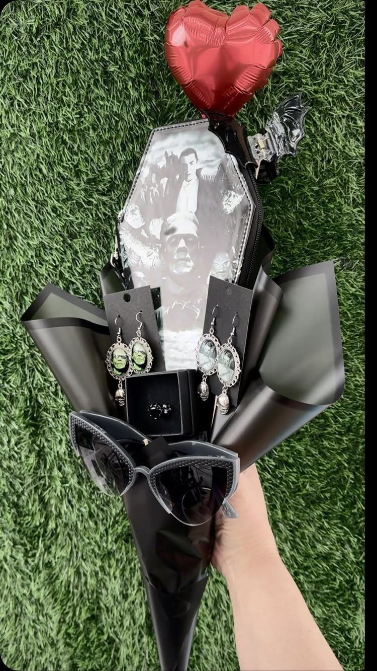 11 Gifts for Halloween Lovers: Candles, Socks and More 7 Gothic gift bouquet with ornate earrings, sunglasses, and a coffin photo frame.