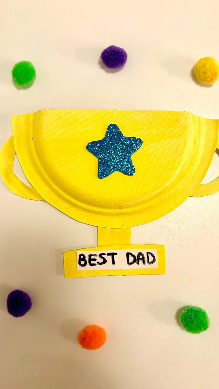 Yellow paper plate trophy with a blue glitter star and Best Dad label.