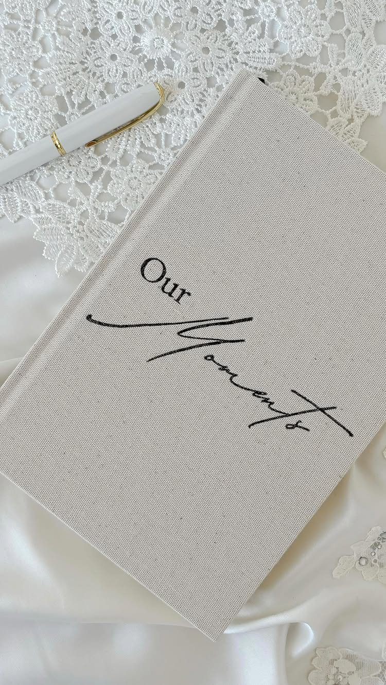 12 Good Gifts for Grandma She'll Actually Use and Treasure 1 Beige linen journal titled Our Moments resting on white satin and lace fabric.