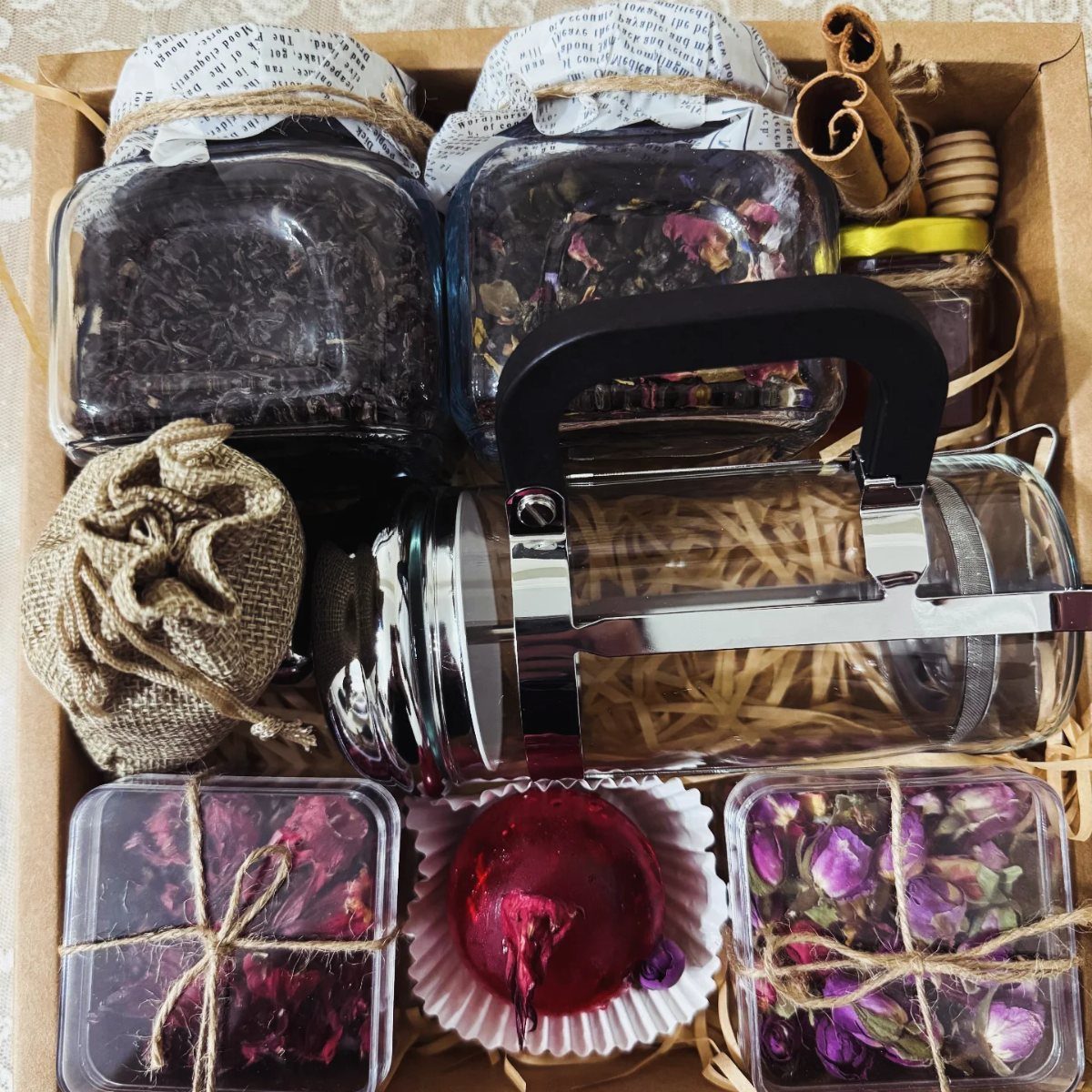 12 Good Gifts for Grandma She'll Actually Use and Treasure 2 Tea gift set in a cardboard box with loose tea, French press, and honey.