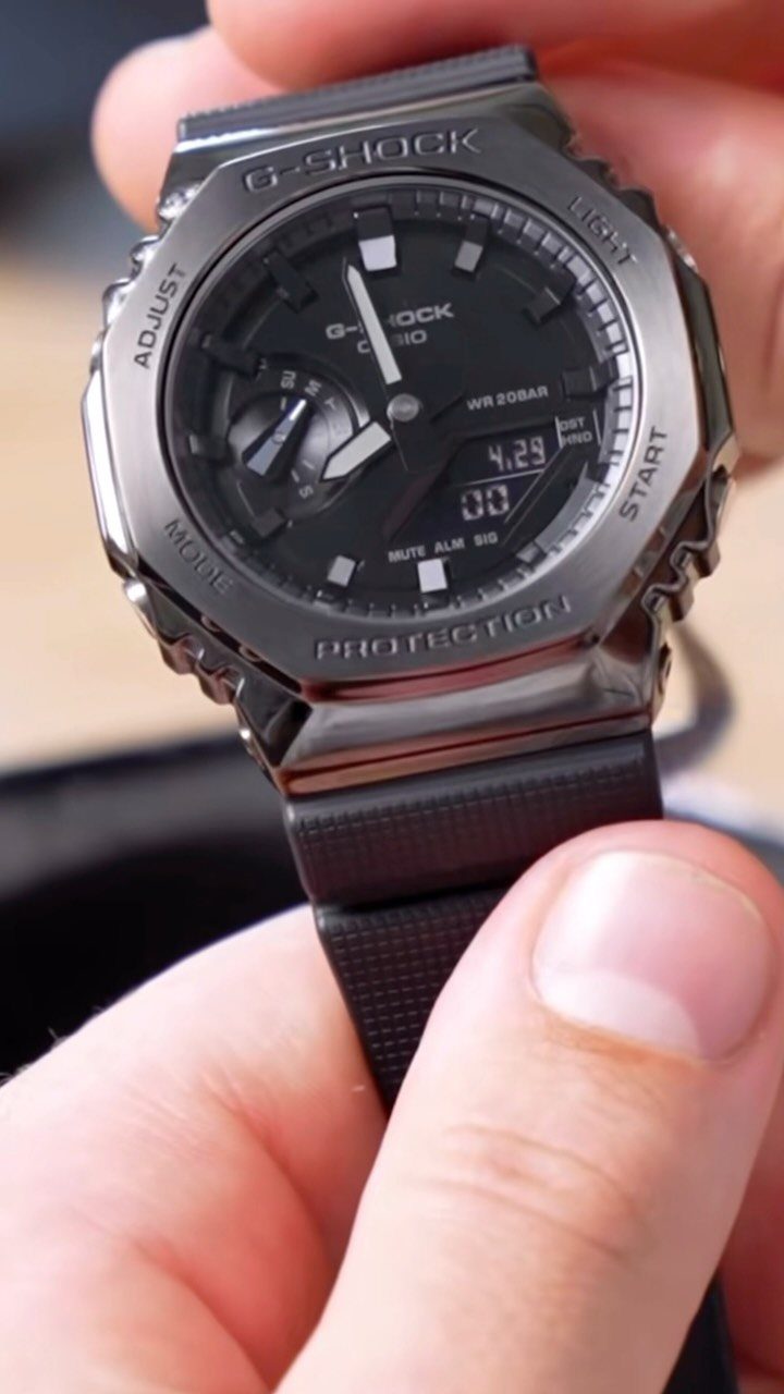Black Casio G-Shock 2100 watch held in a person's hand.