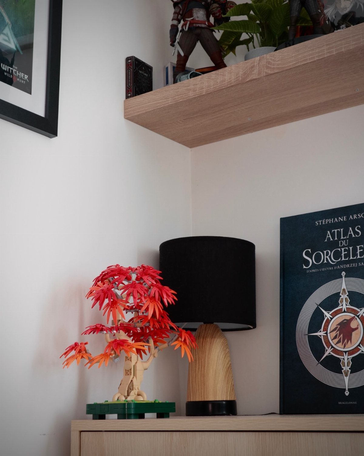 Lego bonsai tree with red leaves on a dresser next to a lamp
