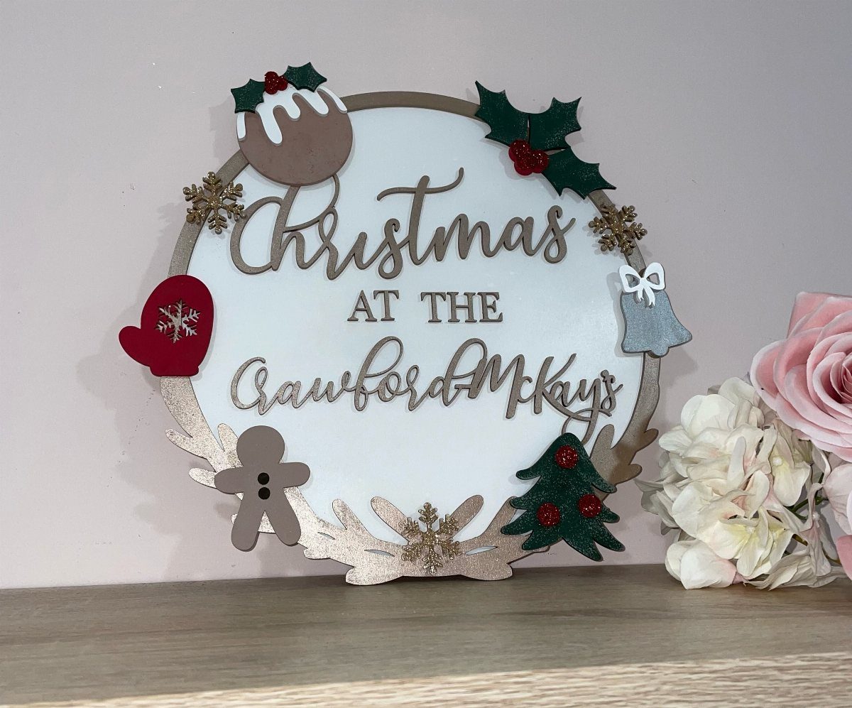 Circular white wooden Christmas sign personalized with the Crawford McKays family name.