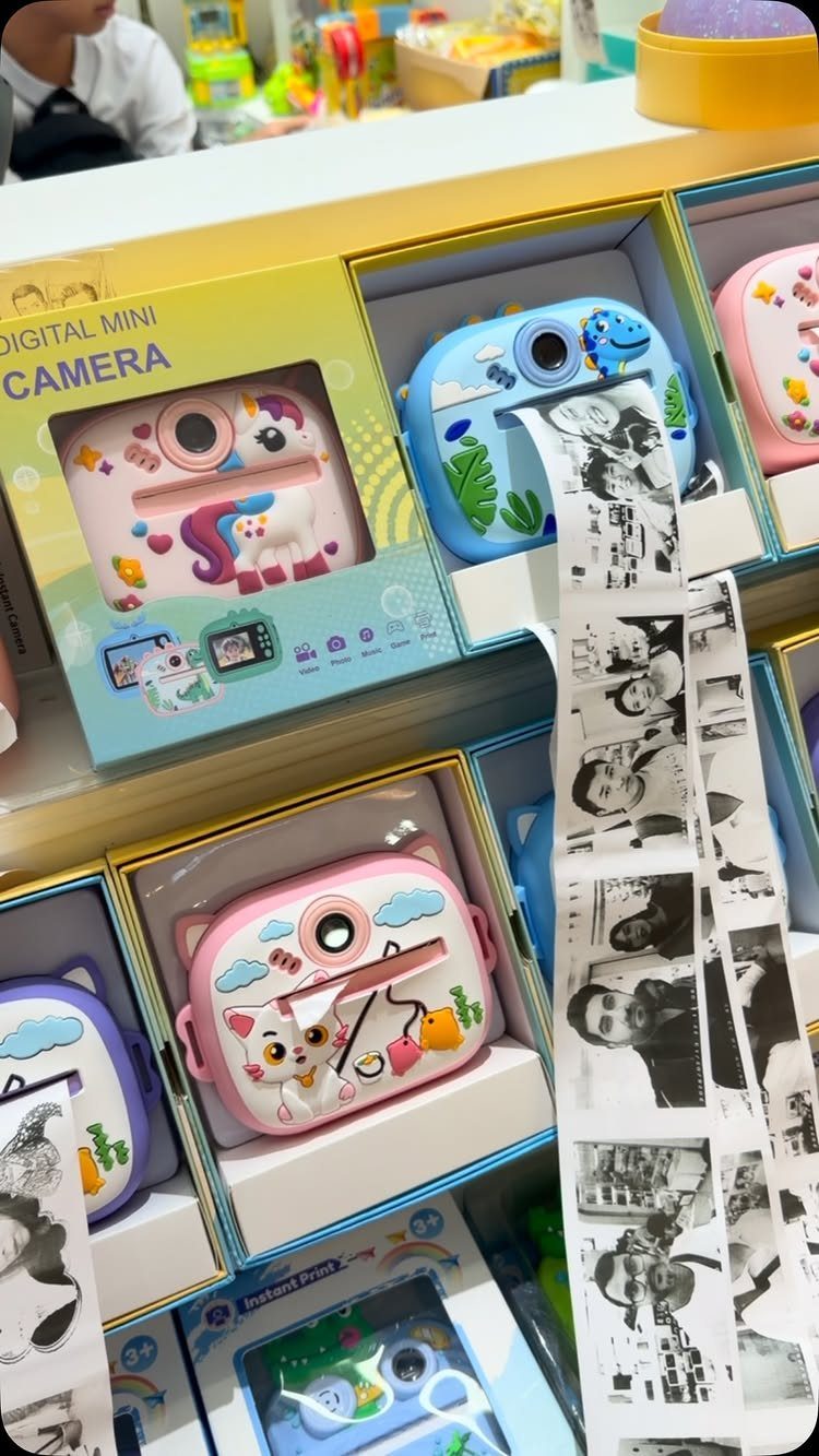 14 Holiday Christmas Gifts for Kids, Couples and Coworkers 11 Colorful digital mini cameras for kids in boxes with a printed photo strip.