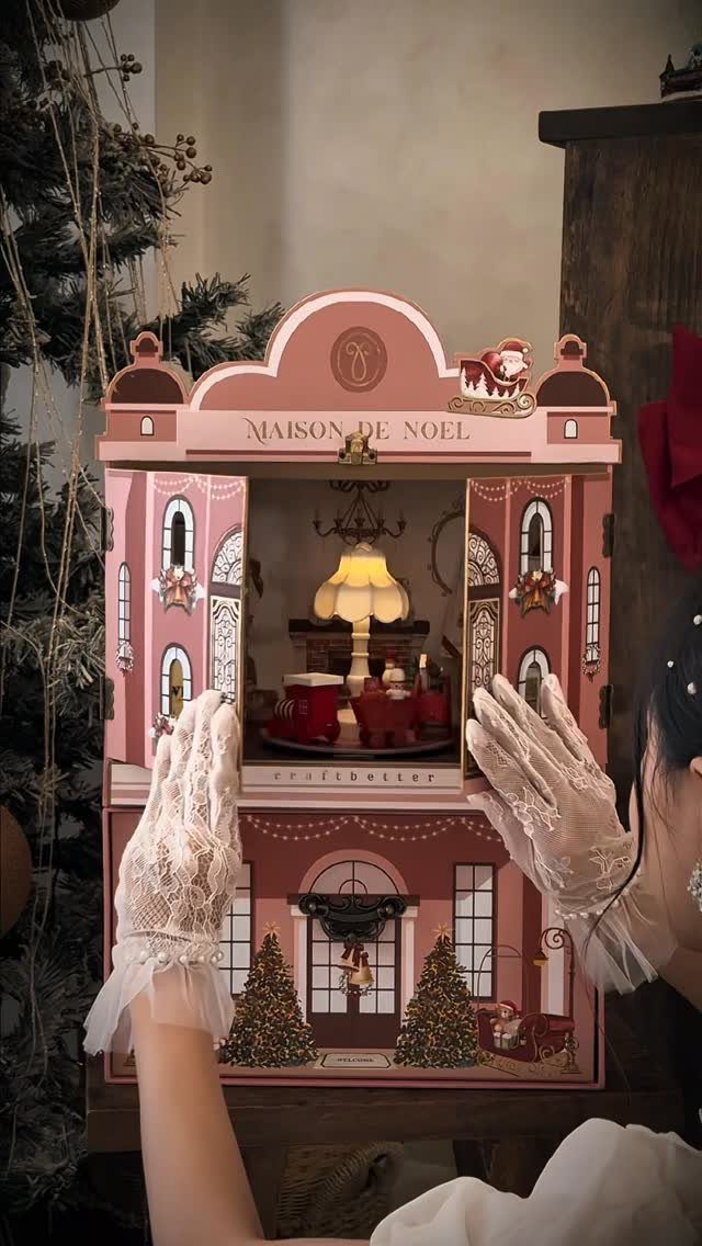 14 Holiday Christmas Gifts for Kids, Couples and Coworkers 8 Ornate pink miniature Christmas house display held by hands in white lace gloves.
