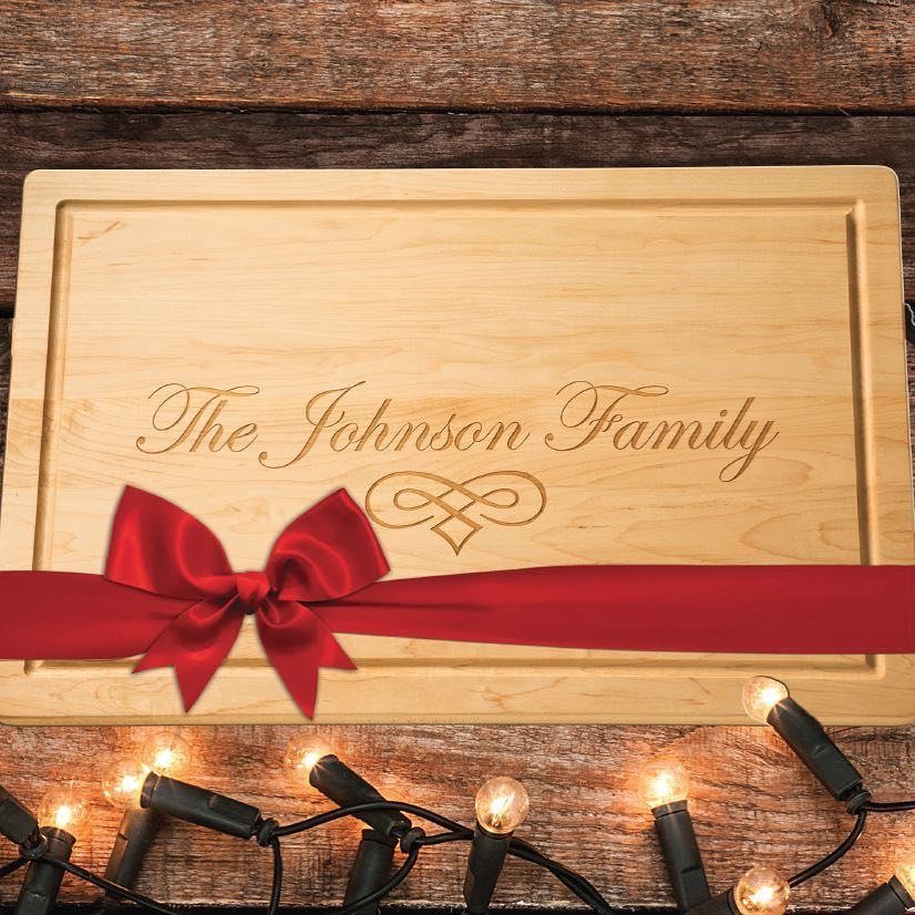 14 Holiday Christmas Gifts for Kids, Couples and Coworkers 1 Engraved wooden cutting board with a red ribbon bow on rustic wood background.