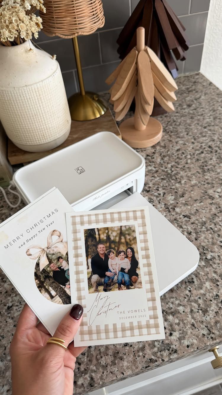 14 Holiday Christmas Gifts for Kids, Couples and Coworkers 7 Hand holding printed Christmas cards with family photos next to a photo printer.
