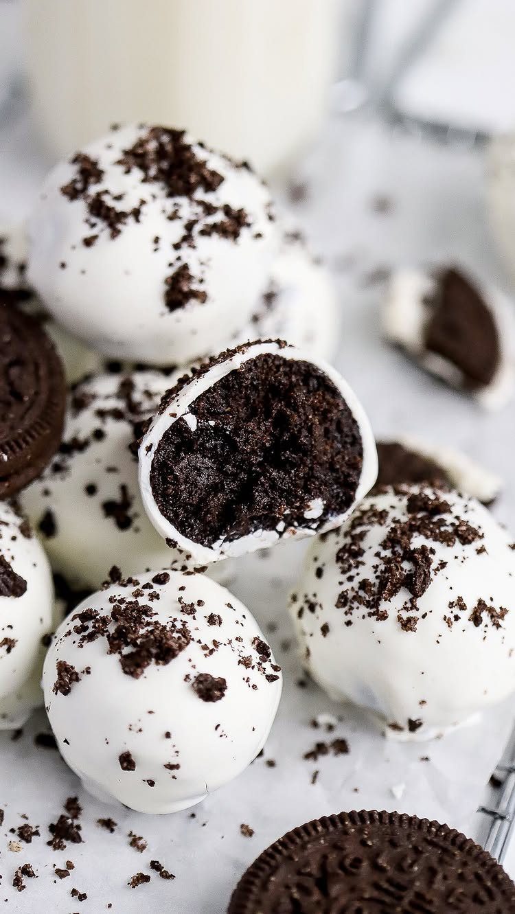 5 Holiday Coworker Gift Ideas for Every Budget 2 White chocolate cake pops with cookie crumbs and chocolate sandwich cookies on parchment.