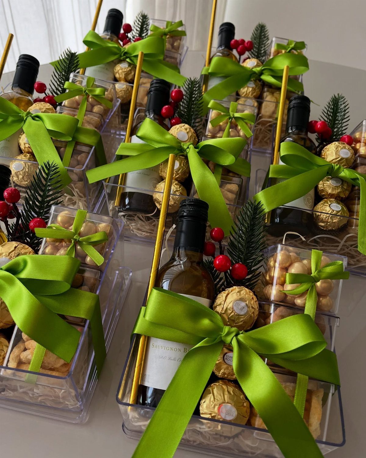 Holiday Wine Gift Ideas: 6 Baskets, Sets, and Sparkling Picks 1 Wine gift baskets with green ribbons, chocolates, and nuts in clear packaging.