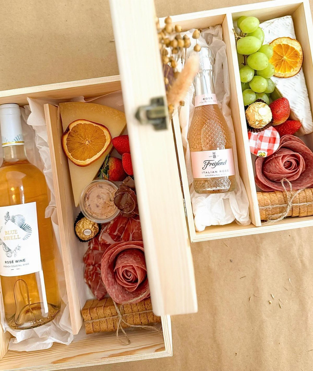 Holiday Wine Gift Ideas: 6 Baskets, Sets, and Sparkling Picks 5 Two wooden gift boxes filled with wine, charcuterie, cheese, and fresh fruit.