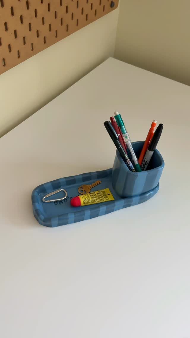 9 Homemade Father's Day Gifts Dad Will Actually Use 9 Blue striped ceramic desk organizer holding pens, pencils, a key, and a carabiner.