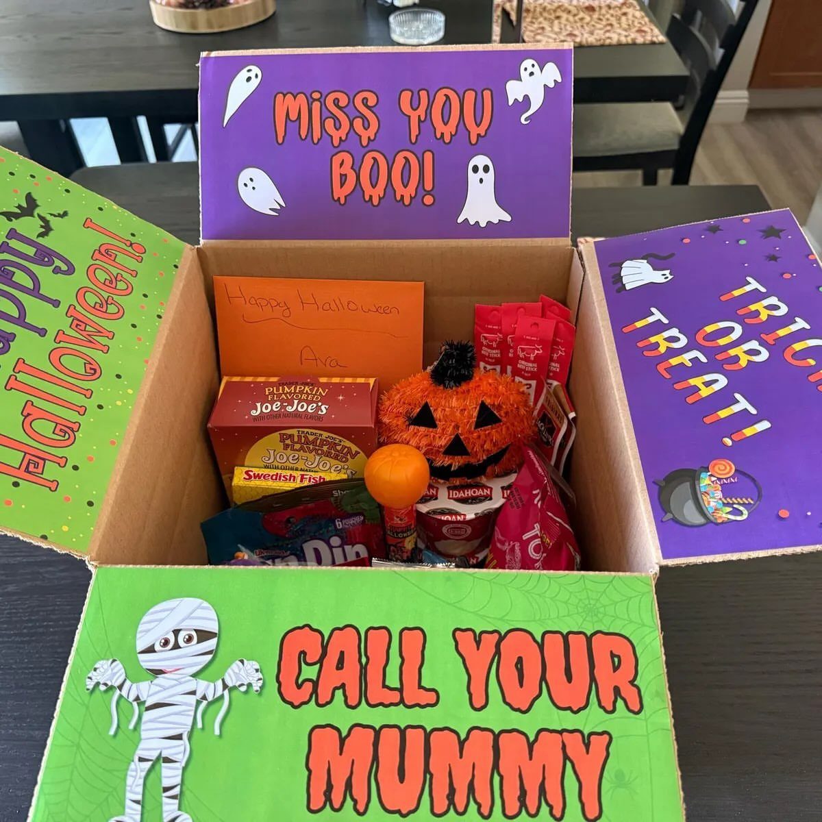 Open Halloween care package box filled with candy and festive themed puns.