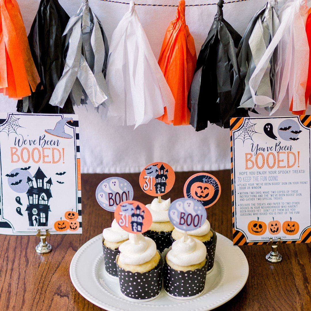 Halloween cupcakes with themed toppers and You've Been Booed signs on a table