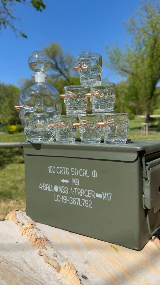 Hunting Gift Basket Ideas: 7 Options to Give This Year 2 Skull-shaped glassware and bullets arranged inside a green metal ammunition can outdoors.
