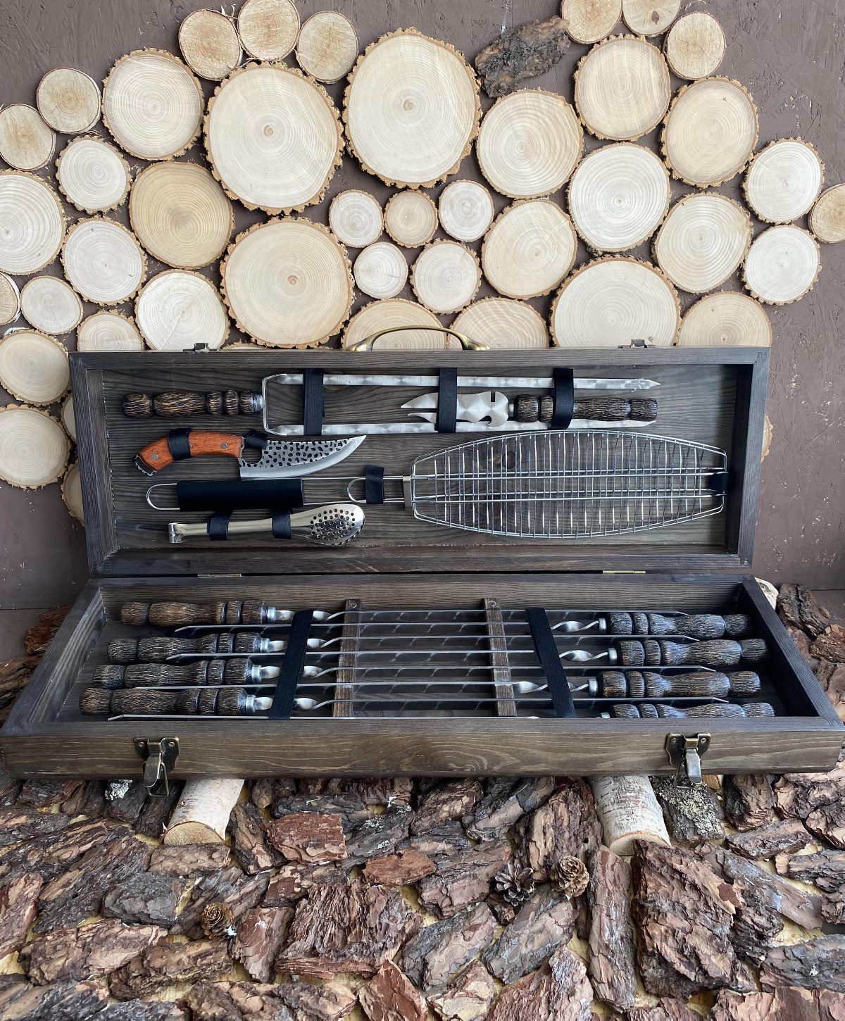 Hunting Gift Basket Ideas: 7 Options to Give This Year 3 Wooden chest with antler-handled grilling tools set against a rustic wood slice background
