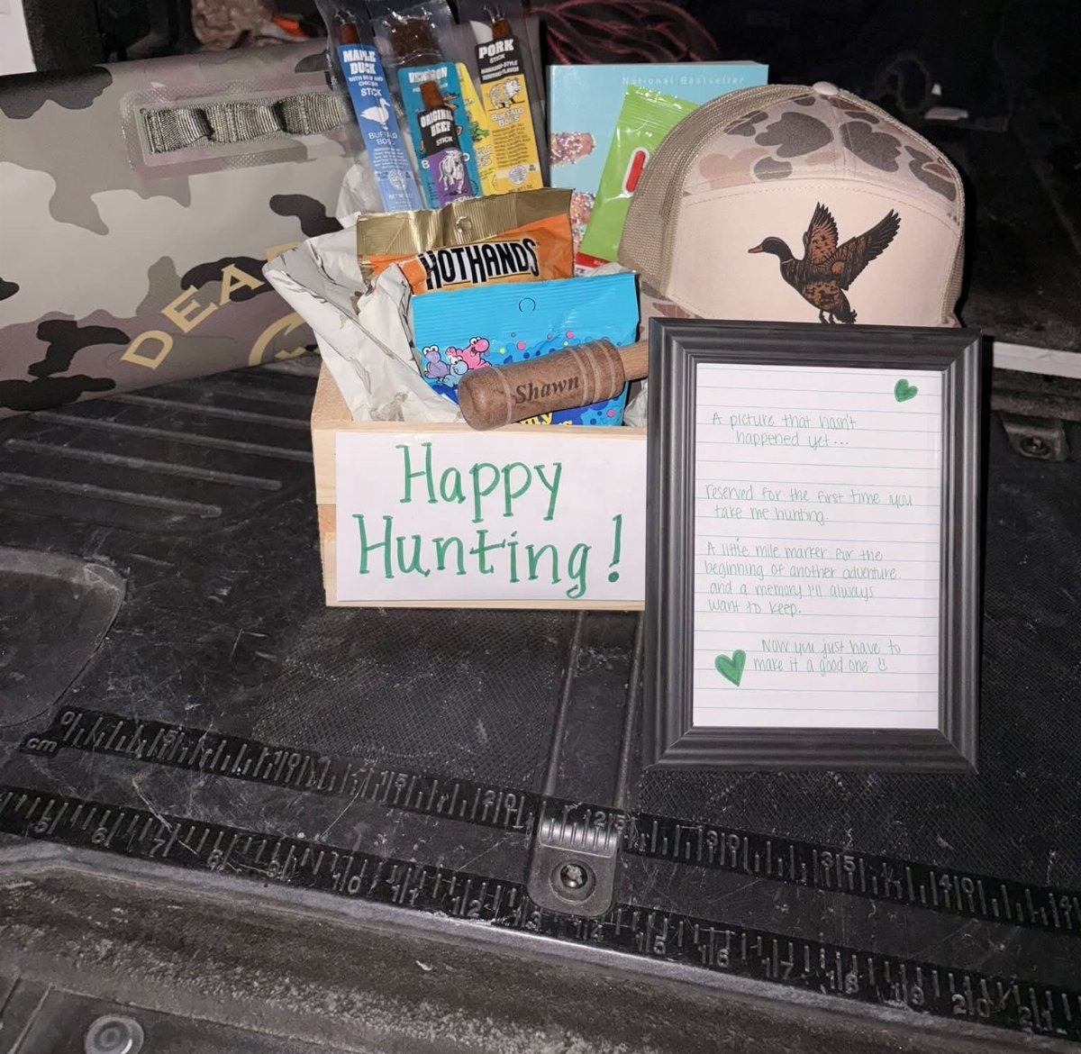 Hunting Gift Basket Ideas: 7 Options to Give This Year 1 Hunting gift basket in a wooden crate with snacks, camo hat, and note.