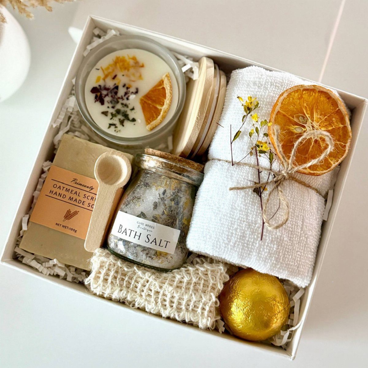 Spa night kit in a white box with bath salts, candle, and towel.