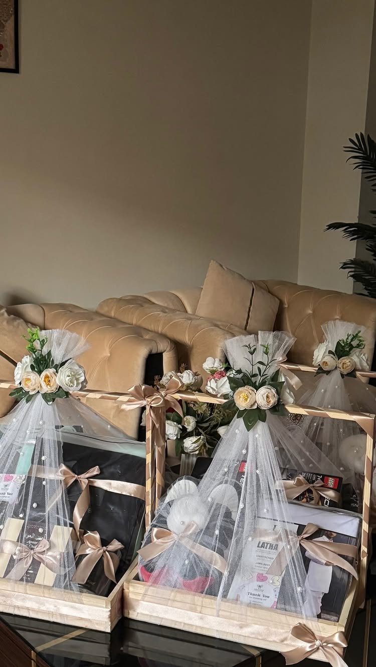 Luxury Gift Basket Ideas: 5 Options for Every Taste 5 Gift baskets wrapped in white tulle with gold ribbons and white floral decorations.