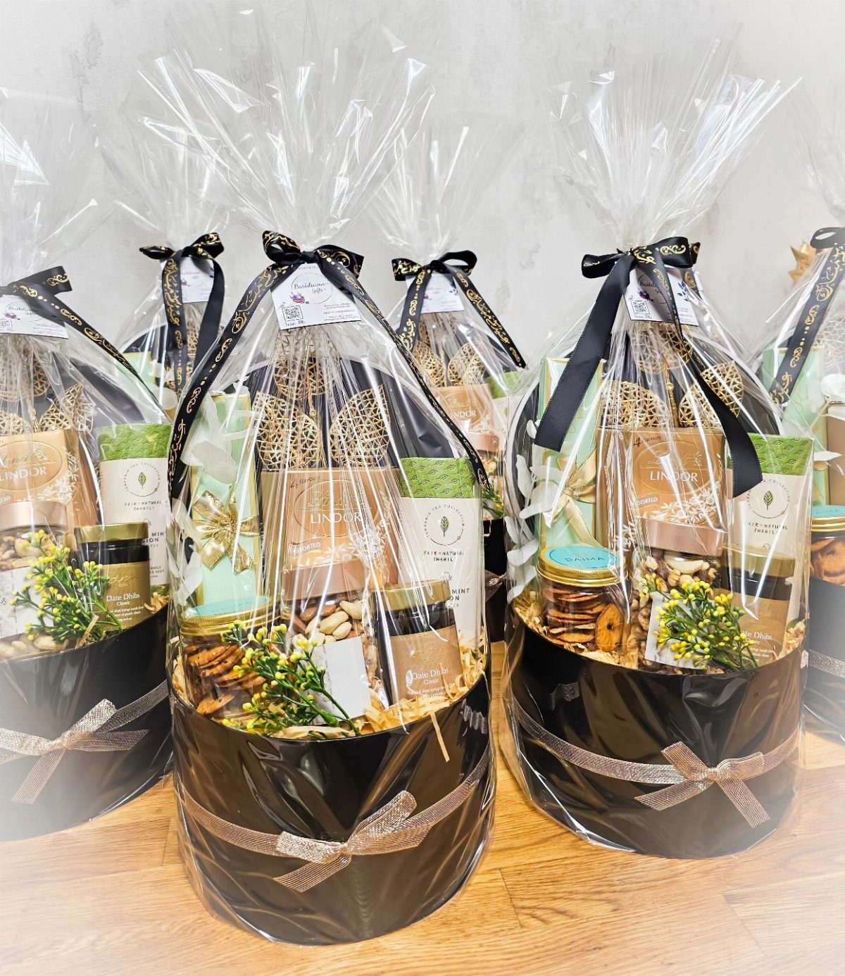 Luxury Gift Basket Ideas: 5 Options for Every Taste 1 Round black gift baskets wrapped in cellophane with gourmet treats and black ribbons.