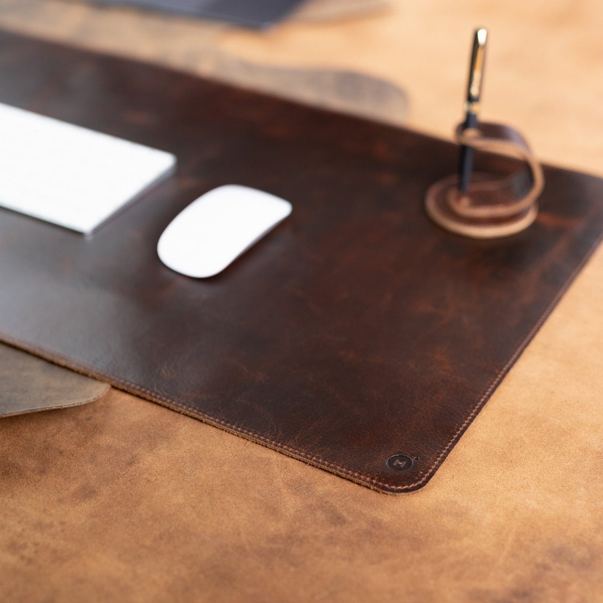 Brown leather desk mat with a white mouse and pen holder