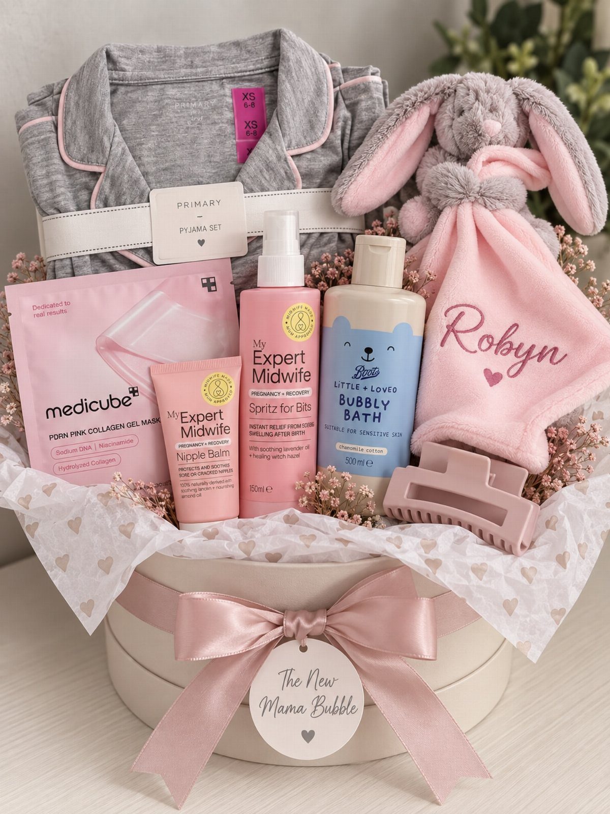 Postpartum Gift Basket Ideas for New Moms: 9 Picks 1 Gift basket with grey pajamas, pink bunny plush, and skincare for a new mother.