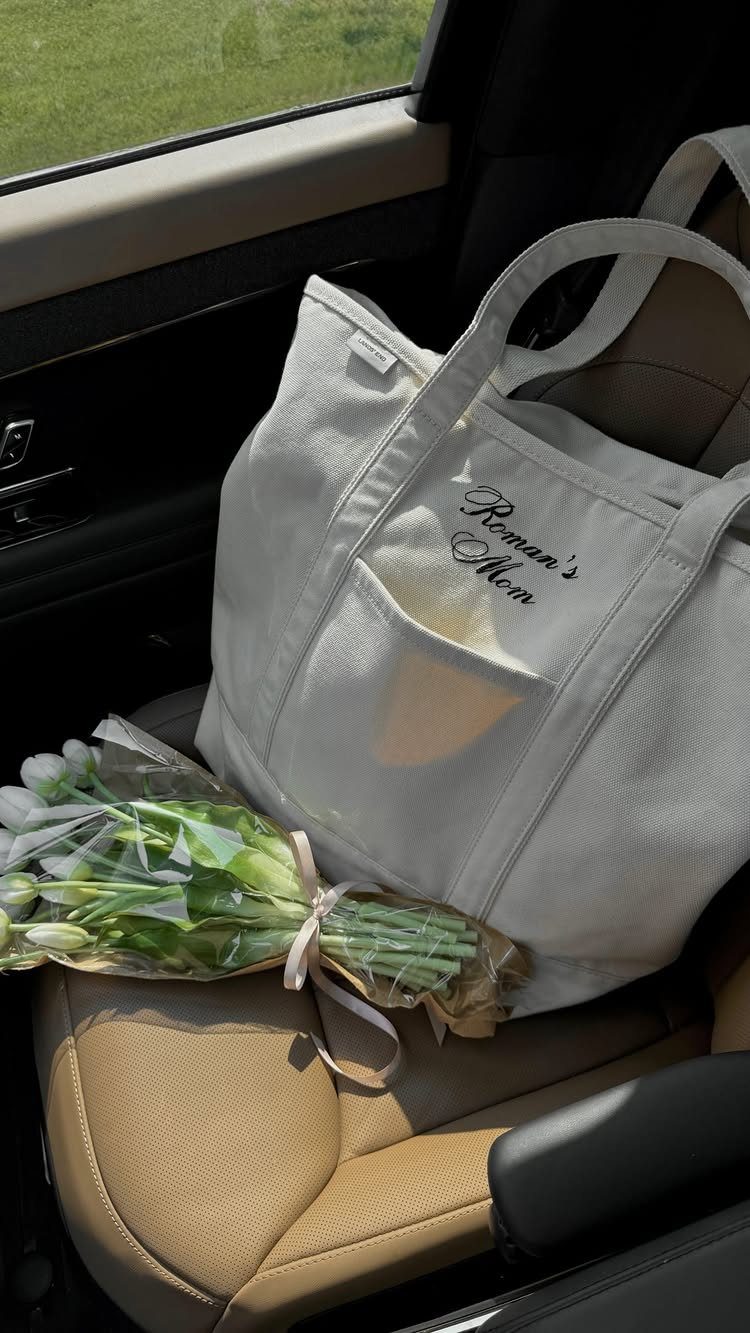 Postpartum Gift Basket Ideas for New Moms: 9 Picks 8 White canvas tote bag and white tulips on a tan car seat