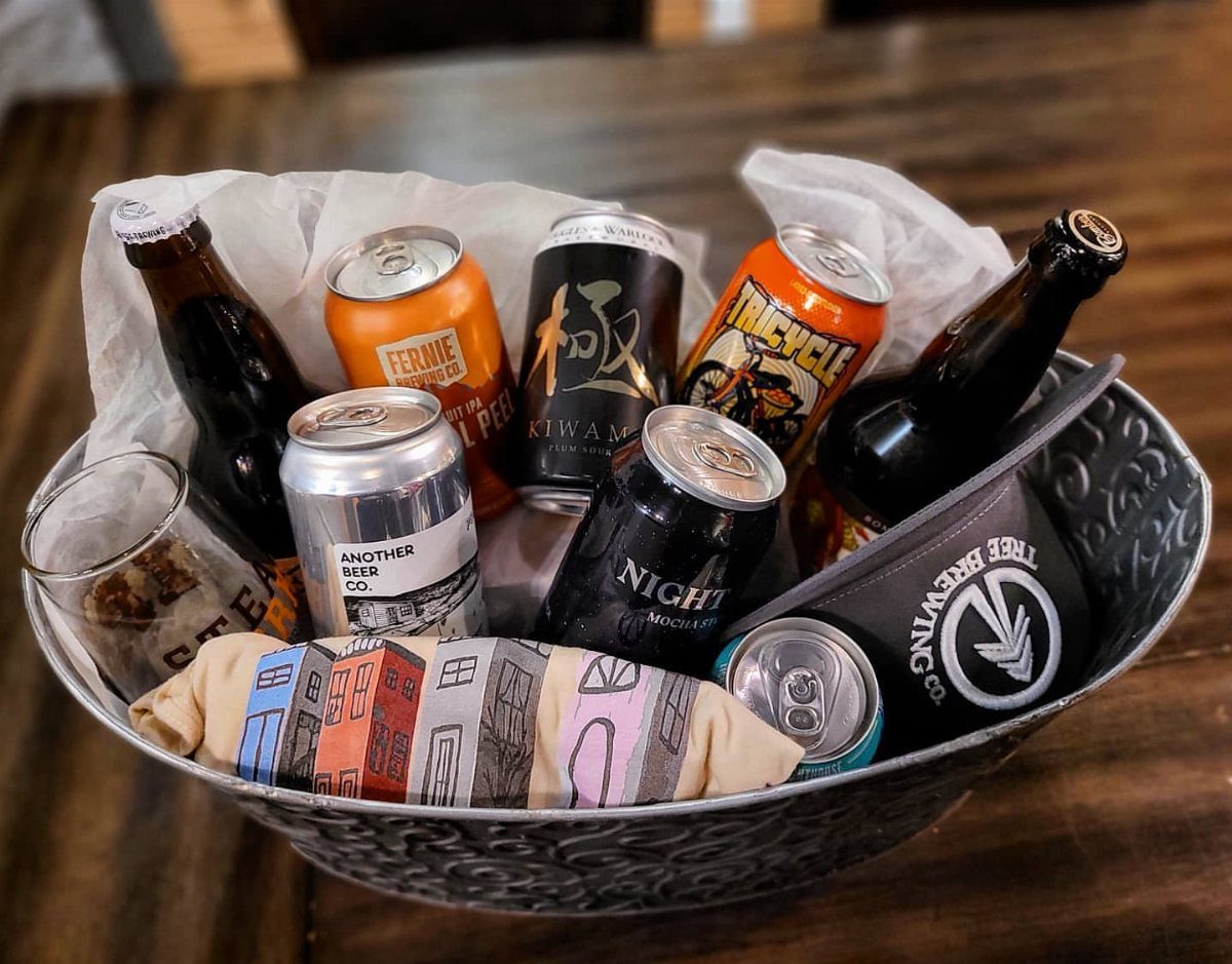 Craft beer gift basket with assorted cans and bottles in a metal bowl.