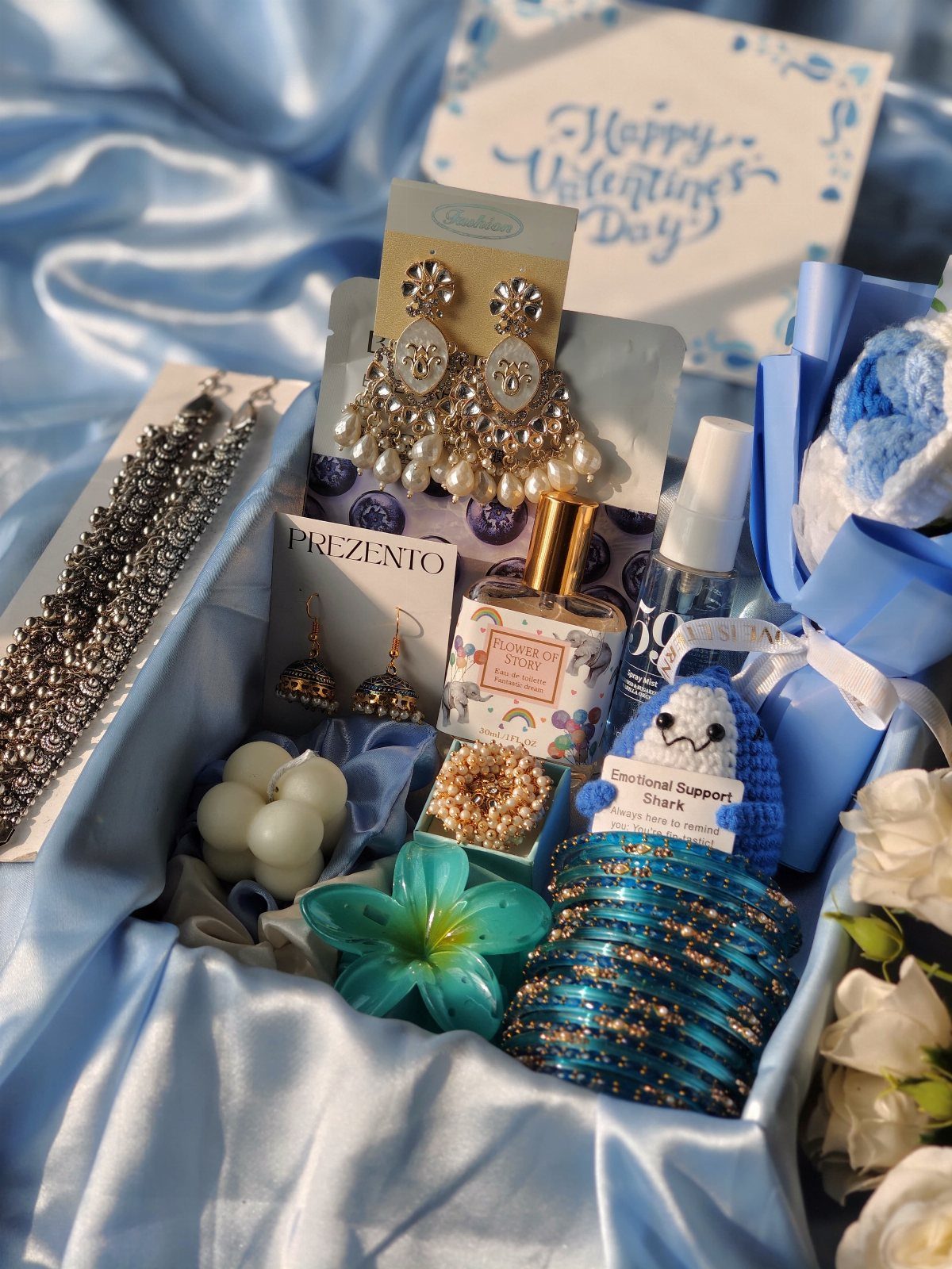 Self Care Gift Box Ideas for Any Occasion: 5 Picks 2 Gift box with blue satin lining containing jewelry, perfume, and a crochet shark.